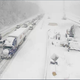 A closed section of Interstate 95 near Fredericksburg, Virginia with cars and trucks stranded on a snowy roadway.